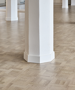 Nytt golv från Tarkett med vita pelare utspridda på golvet.