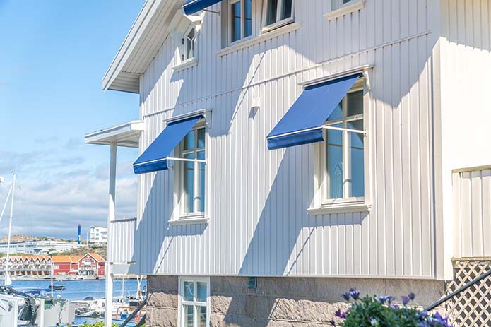 Markiser på fänster på hus vid kusten. Bild av Uddevalla markis och persienn.
