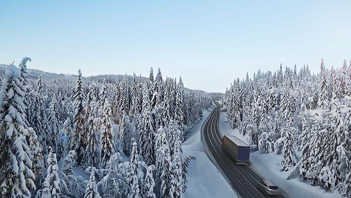 En lastbil och en bil på en väg i en skog med snötäckta träd. Bild av Vattenfall Eldistribution.