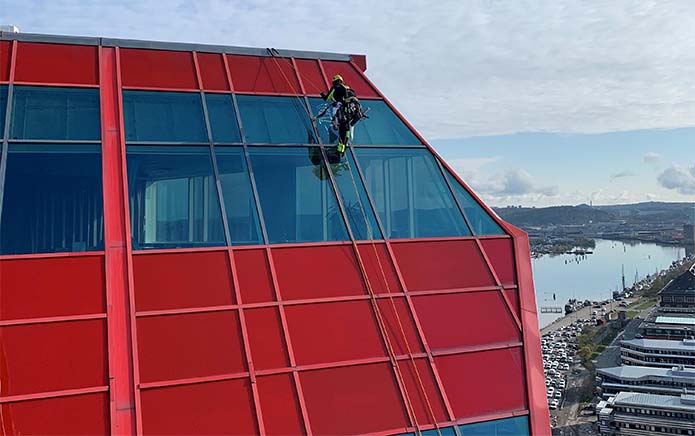 Medarbetare på Ropeteam klättrar ner på utsidan av byggnaden Läppstiftet i Göteborg.